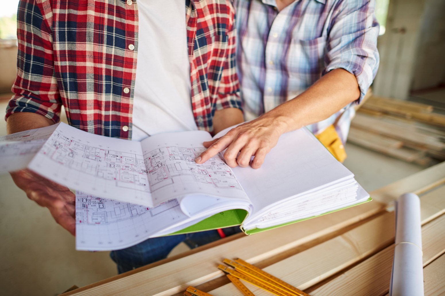 Builder discussing a proposed barndominium layout with homeowners